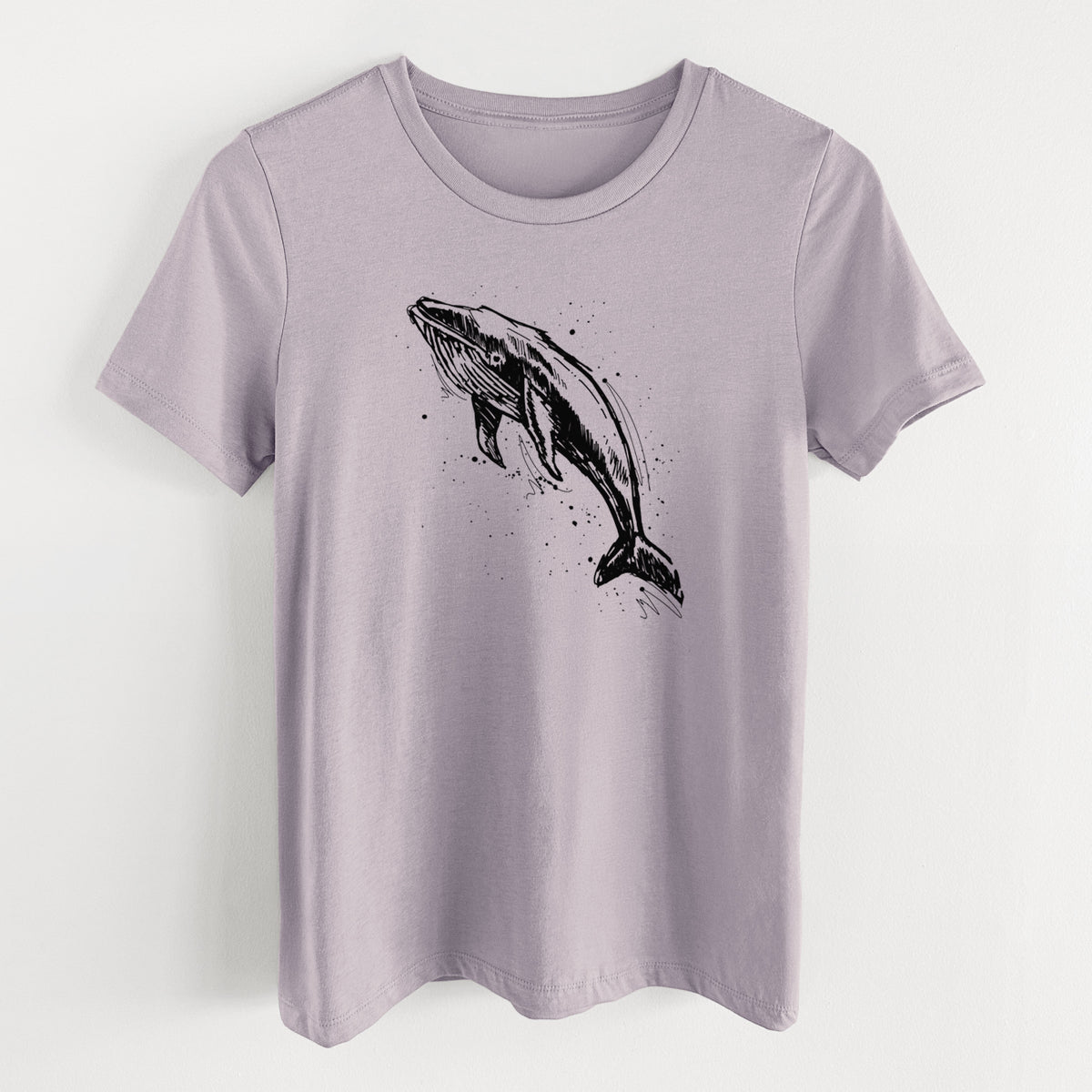 Light violet women's relaxed fit cotton t-shirt laid flat, printed with a black ink illustration of a humpback whale diving, with ink splatters.