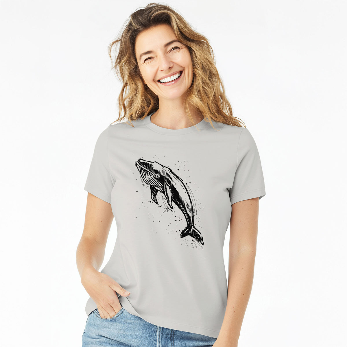 Woman wearing a lunar grey women's relaxed fit cotton t-shirt printed with a black ink illustration of a humpback whale diving, with ink splatters.