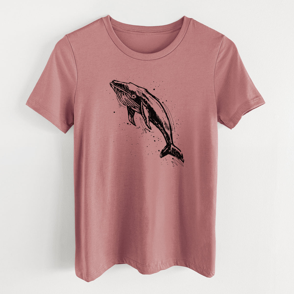 Mauve pink women's relaxed fit cotton t-shirt laid flat, printed with a black ink illustration of a humpback whale diving, with ink splatters.