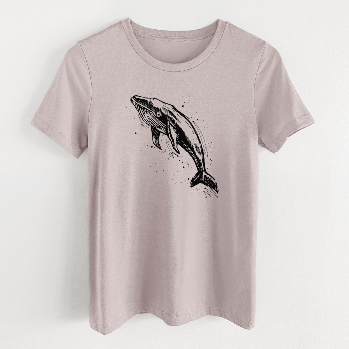 Pink gravel women's relaxed fit cotton t-shirt laid flat, printed with a black ink illustration of a humpback whale diving, with ink splatters.