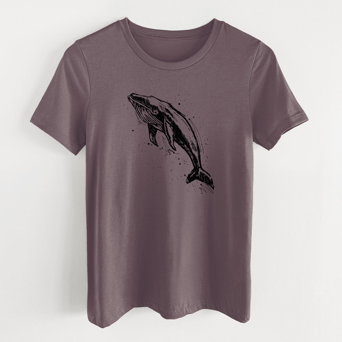 Purple storm women's relaxed fit cotton t-shirt laid flat, printed with a black ink illustration of a humpback whale diving, with ink splatters.