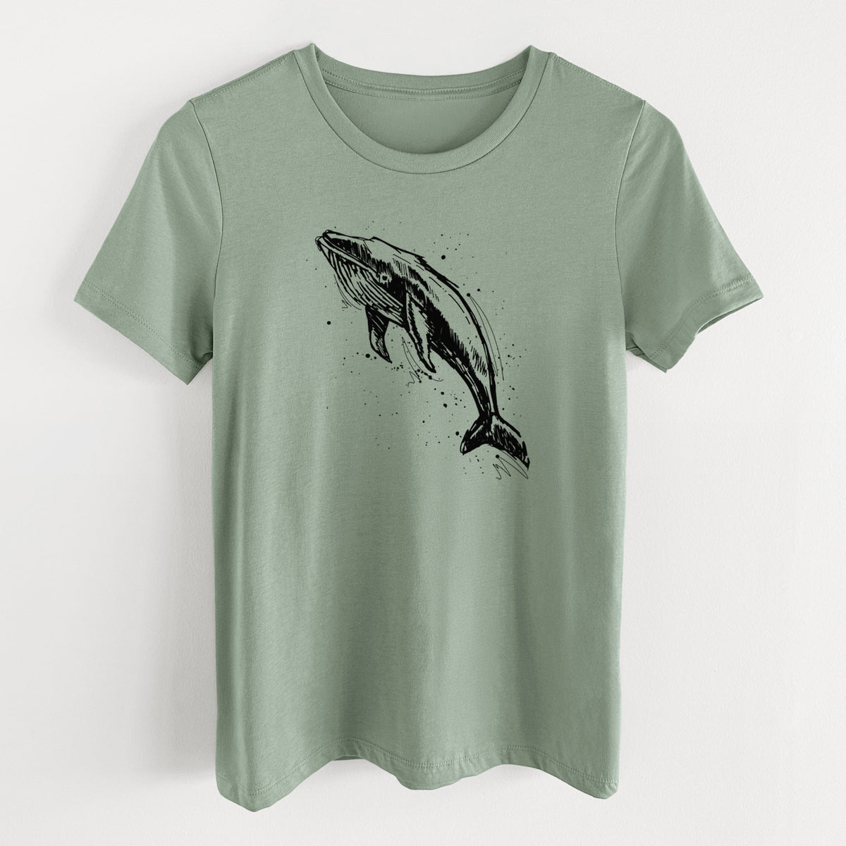 Sage green women's relaxed fit cotton t-shirt laid flat, printed with a black ink illustration of a humpback whale diving, with ink splatters.