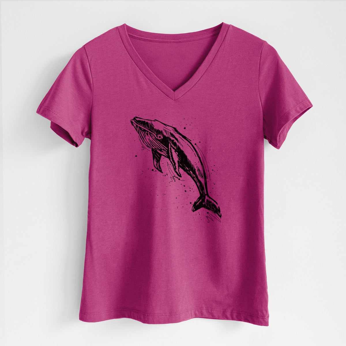 Berry pink women's relaxed fit cotton V-neck t-shirt laid flat, printed with a black ink illustration of a humpback whale diving, with ink splatters.