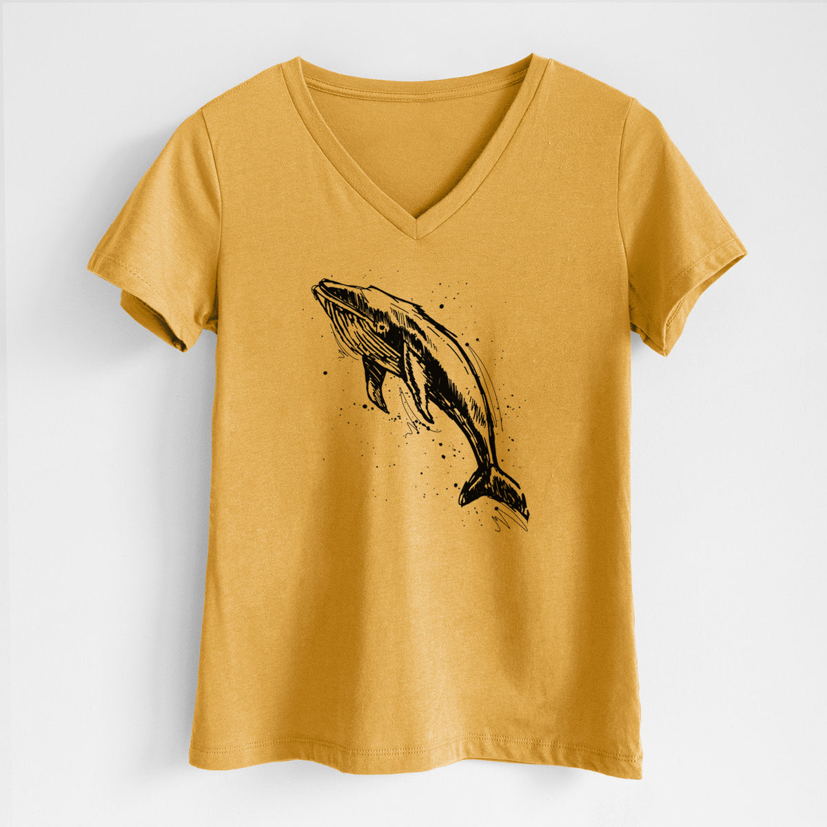 Honeycomb yellow women's relaxed fit cotton V-neck t-shirt laid flat, printed with a black ink illustration of a humpback whale diving, with ink splatters.