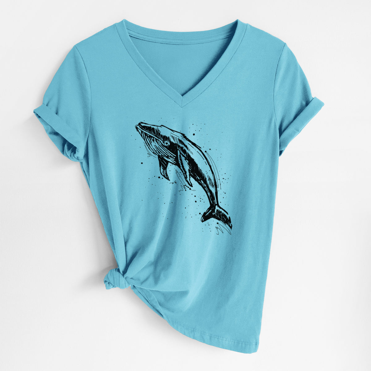 Turquoise women's relaxed fit cotton V-neck t-shirt laid flat, printed with a black ink illustration of a humpback whale diving, with ink splatters.