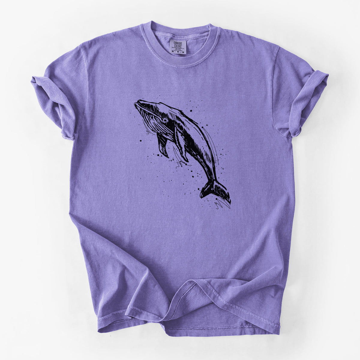 Violet purple Comfort Colors t-shirt laid flat, printed with a black ink illustration of a humpback whale diving, with ink splatters.