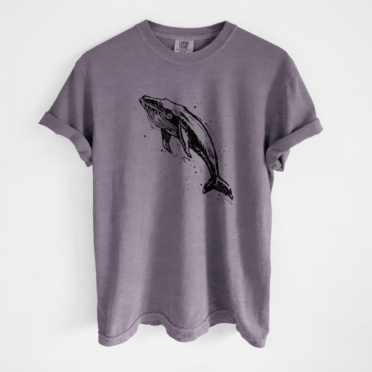Wine red Comfort Colors t-shirt laid flat, printed with a black ink illustration of a humpback whale diving, with ink splatters.