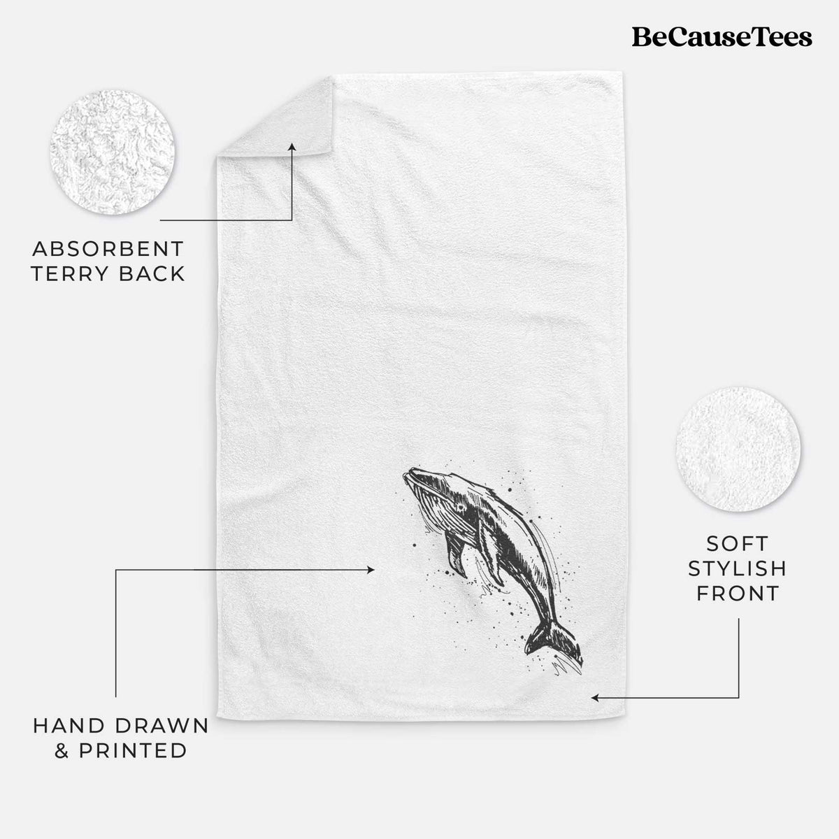 White hand towel printed with a black ink illustration of a humpback whale diving, with ink splatters.
