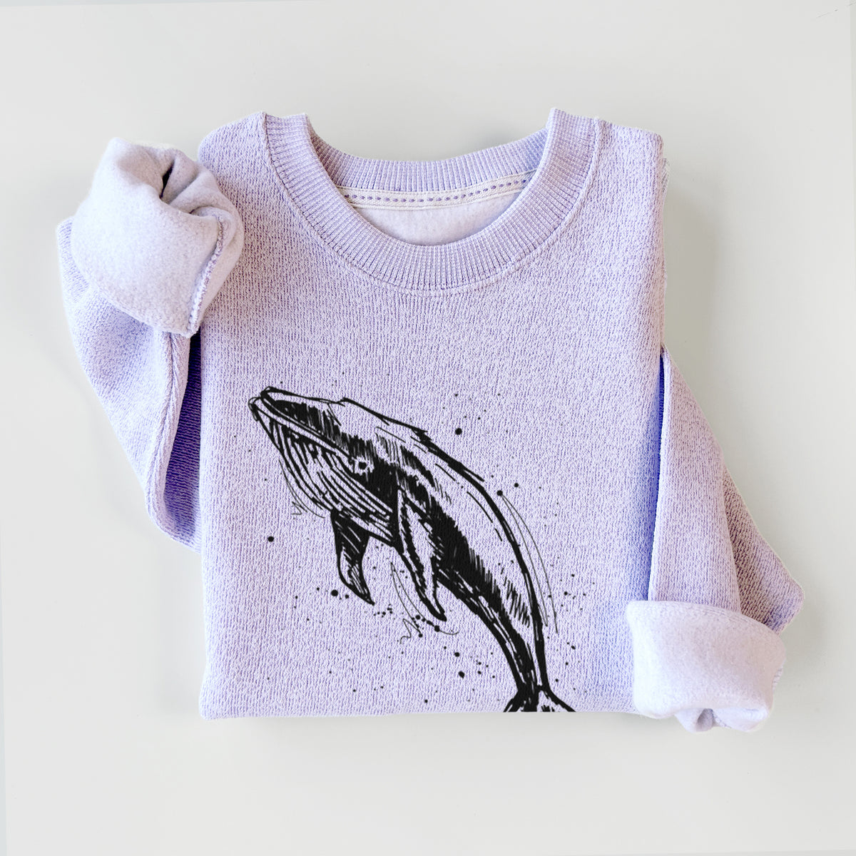 Ice purple knit sweatshirt printed with a black ink illustration of a humpback whale diving, with ink splatters, styled flat.