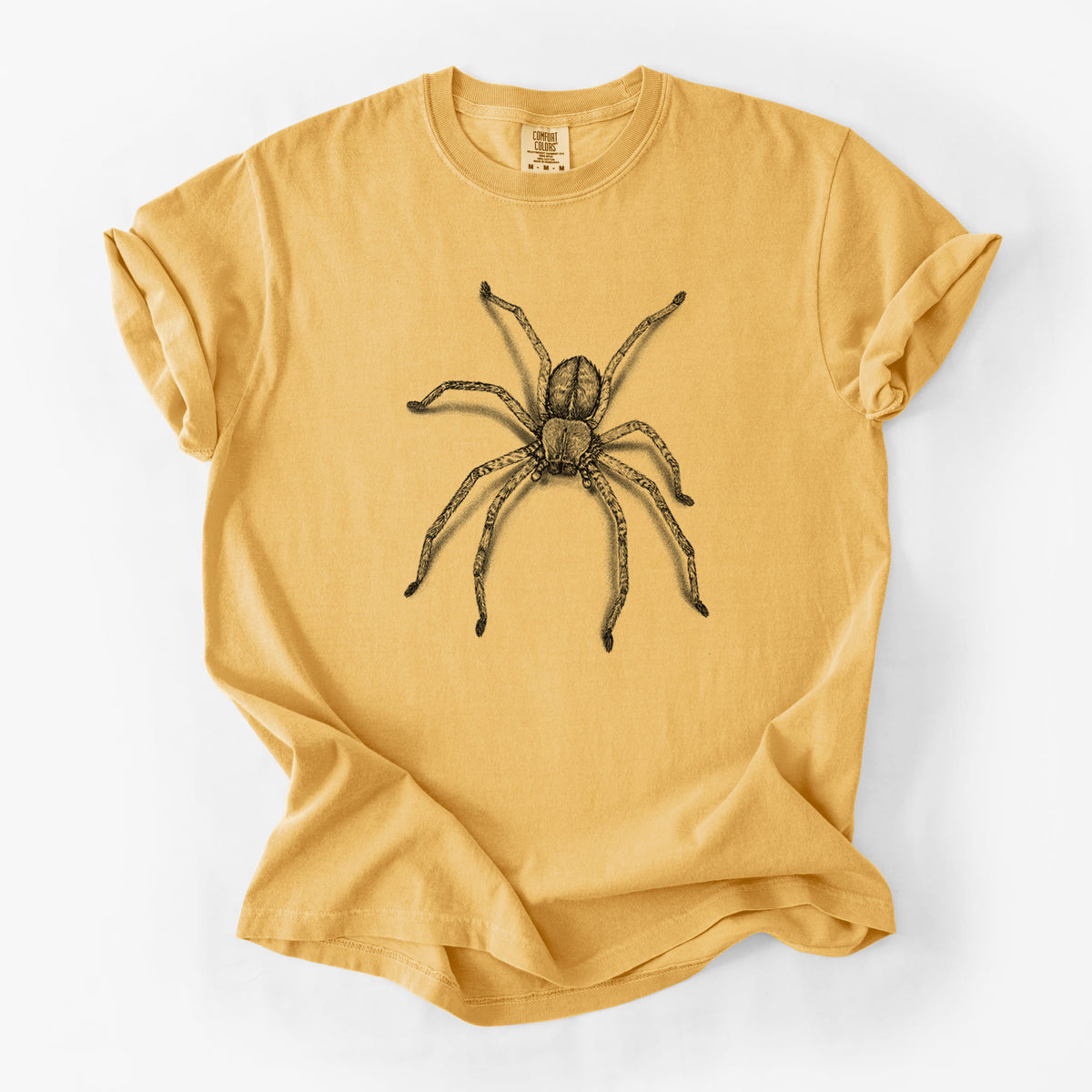 Golden wheat yellow Comfort Colors t-shirt laid flat, printed with a detailed black ink illustration of a huntsman spider with long legs spread.