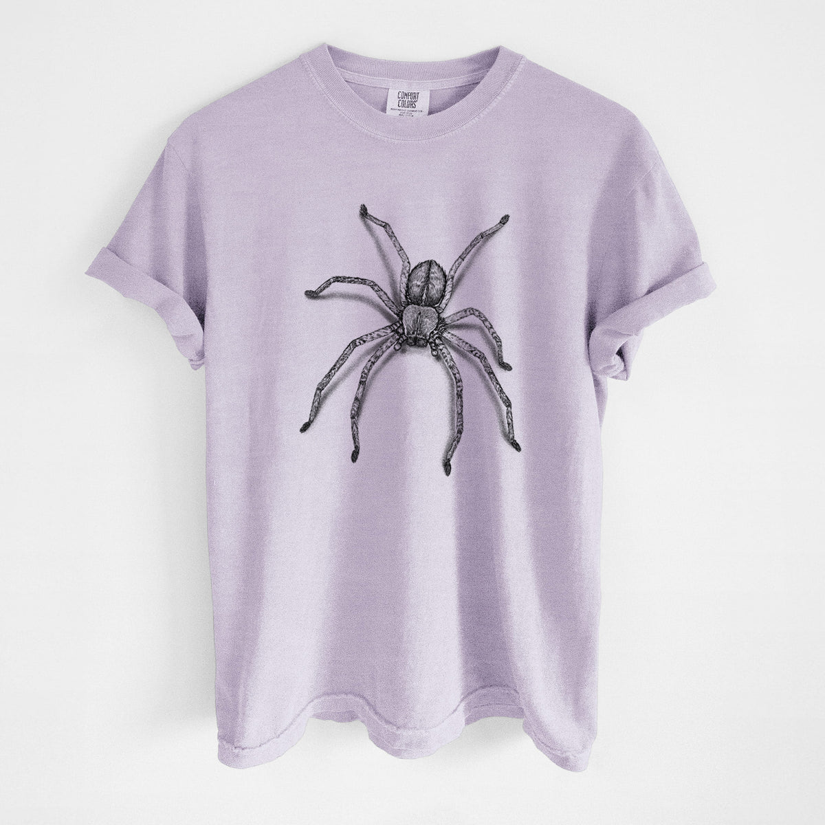 Orchid purple Comfort Colors t-shirt laid flat, printed with a detailed black ink illustration of a huntsman spider with long legs spread.