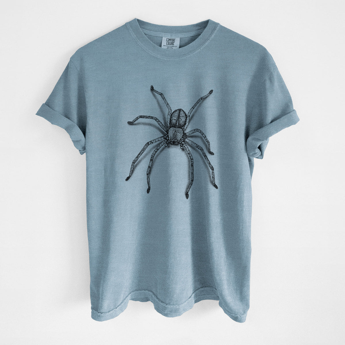 Steel blue Comfort Colors t-shirt laid flat, printed with a detailed black ink illustration of a huntsman spider with long legs spread.