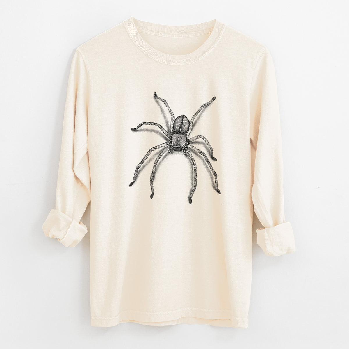 Ivory Comfort Colors long sleeve shirt laid flat with the cuffs rolled, printed with a detailed black ink illustration of a huntsman spider with long legs spread.