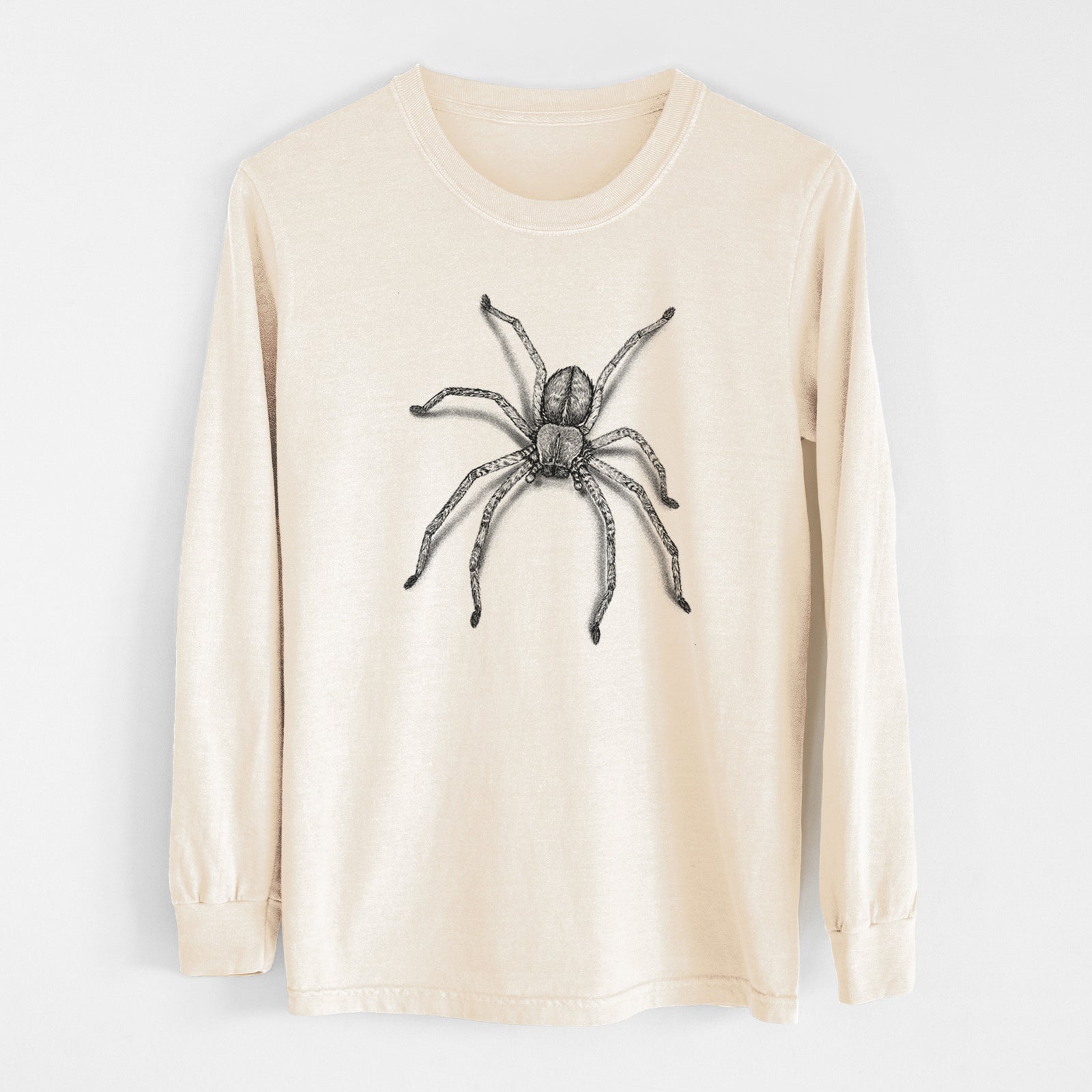 Ivory Comfort Colors long sleeve shirt laid flat, printed with a detailed black ink illustration of a huntsman spider with long legs spread.