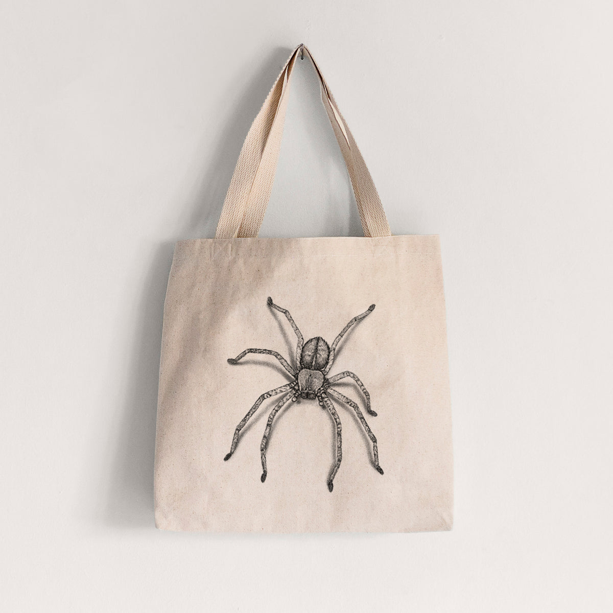 Natural canvas tote bag printed with a detailed black ink illustration of a huntsman spider with long legs spread.