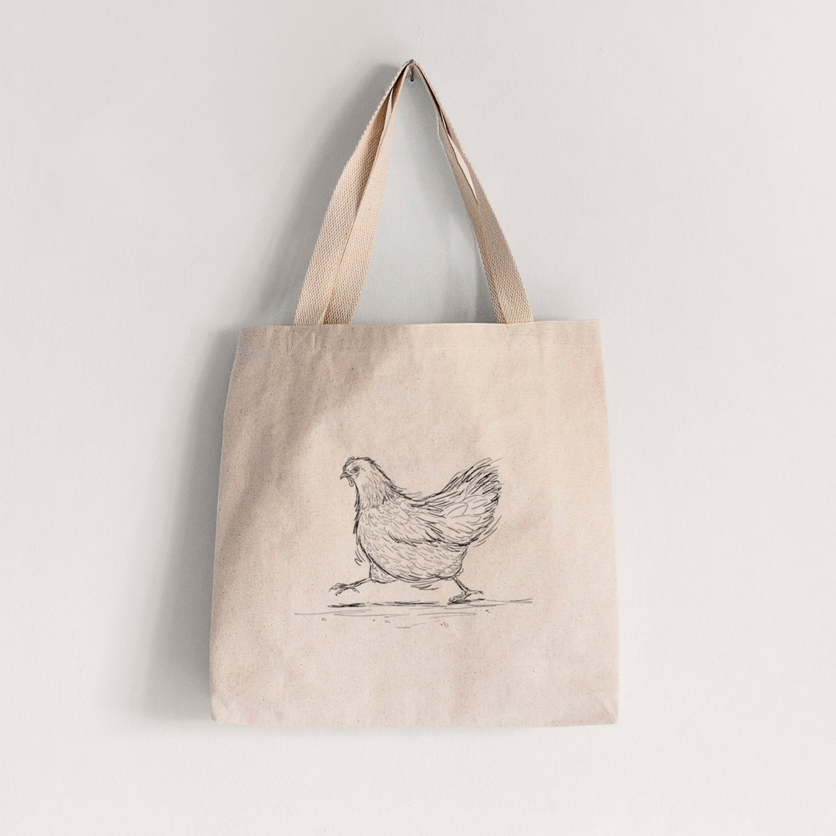 Natural canvas tote bag printed with a black ink sketch of a hen hurrying along.