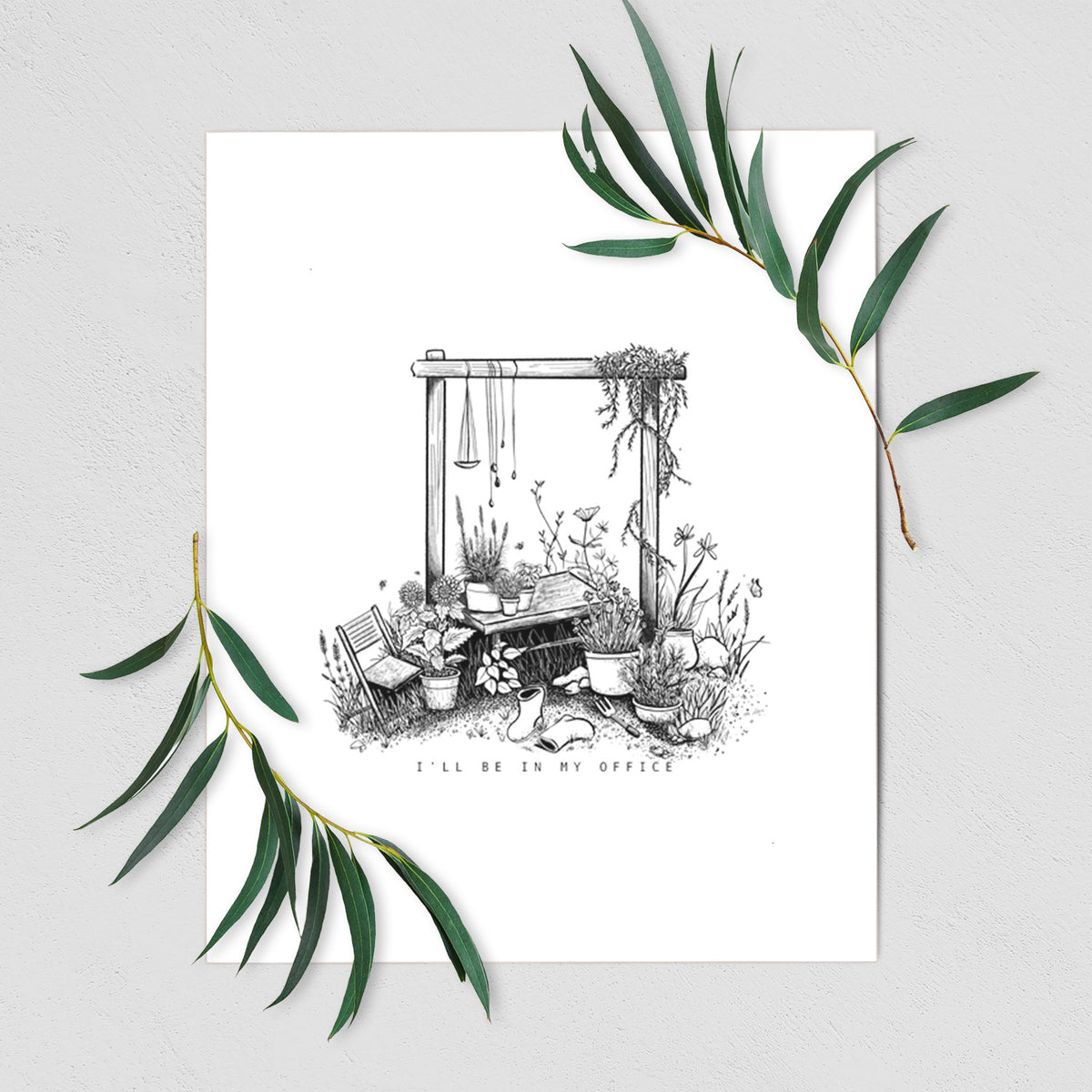 Art print of a black ink illustration of a garden gate arch surrounded by potted plants and flowers, shown with eucalyptus leaves.