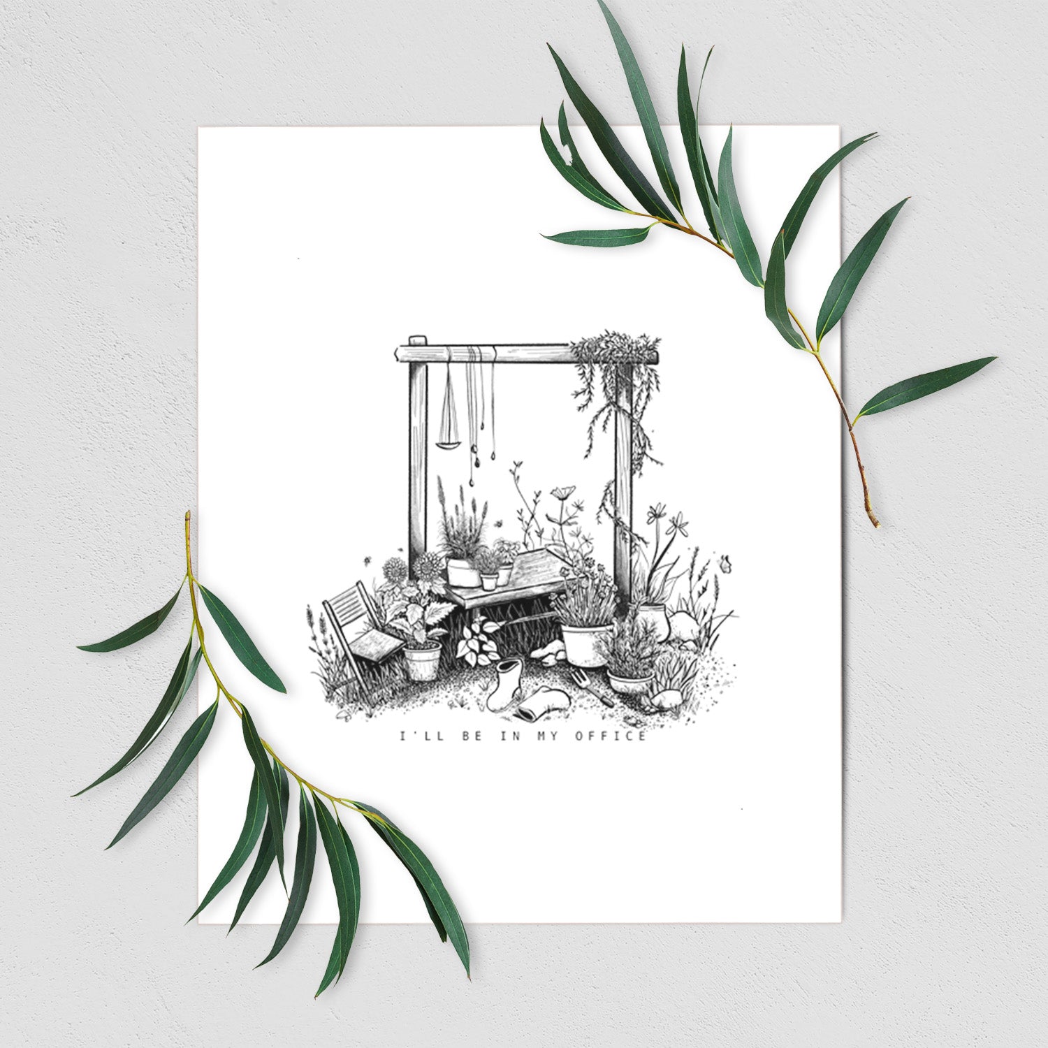 Art print of a black ink illustration of a garden gate arch surrounded by potted plants and flowers, shown with eucalyptus leaves.