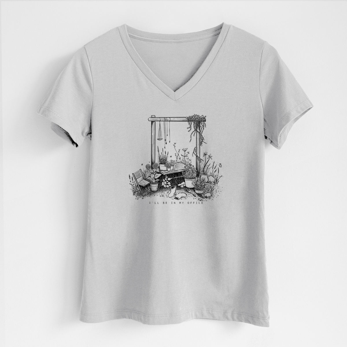 Lunar grey women's relaxed fit cotton V-neck t-shirt laid flat, printed with a black ink illustration of a garden gate arch surrounded by potted plants and flowers.