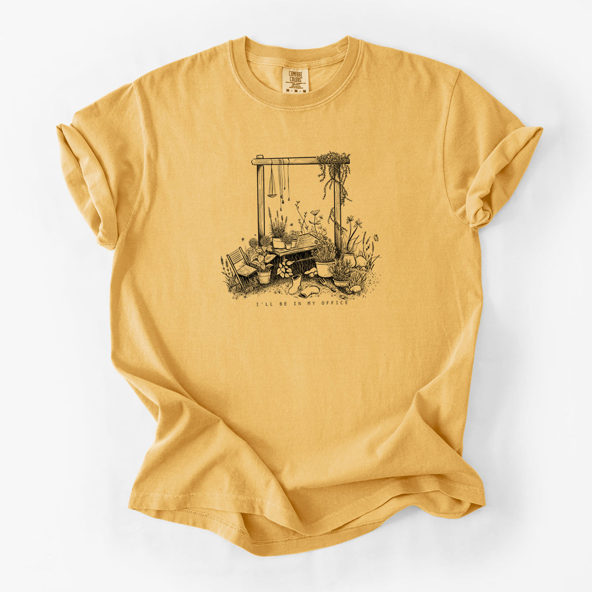 Golden wheat yellow Comfort Colors t-shirt laid flat, printed with a black ink illustration of a garden gate arch surrounded by potted plants and flowers.