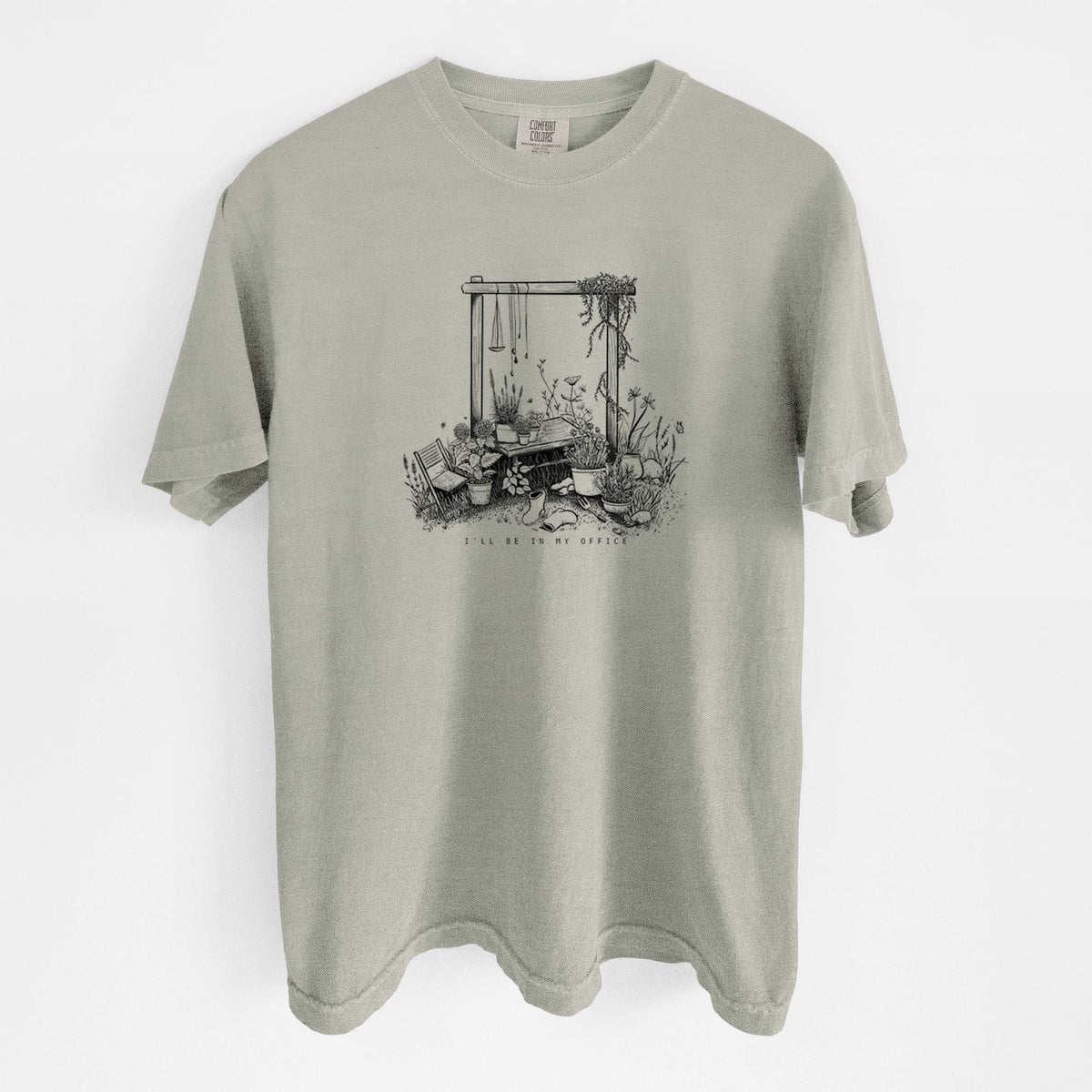 Sandstone beige Comfort Colors t-shirt laid flat, printed with a black ink illustration of a garden gate arch surrounded by potted plants and flowers.