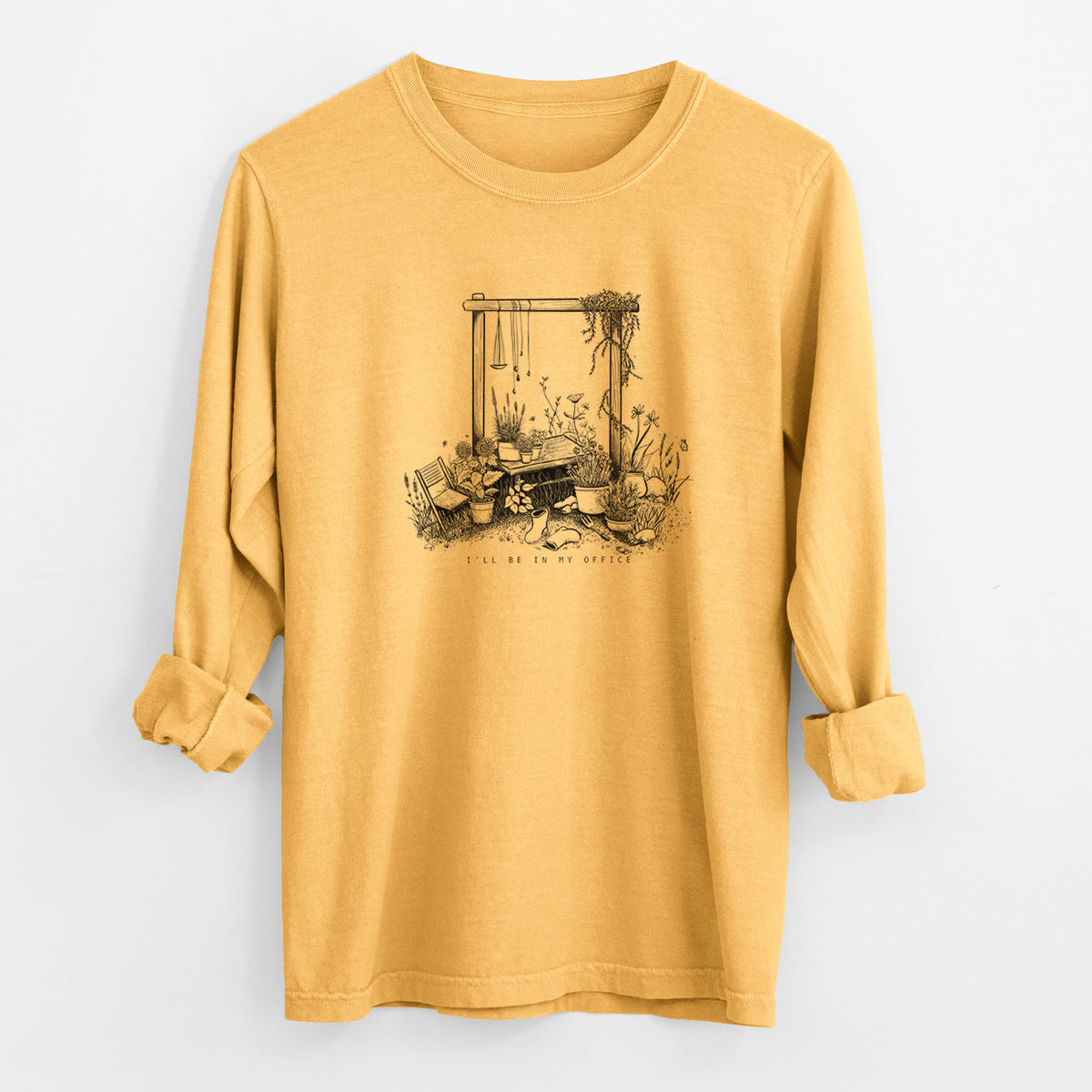 Golden wheat yellow Comfort Colors long sleeve shirt laid flat with the cuffs rolled, printed with a black ink illustration of a garden gate arch surrounded by potted plants and flowers.