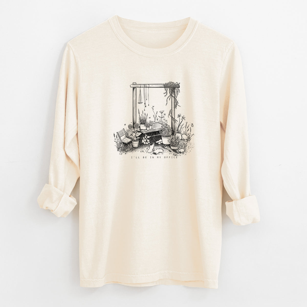 Ivory Comfort Colors long sleeve shirt laid flat with the cuffs rolled, printed with a black ink illustration of a garden gate arch surrounded by potted plants and flowers.