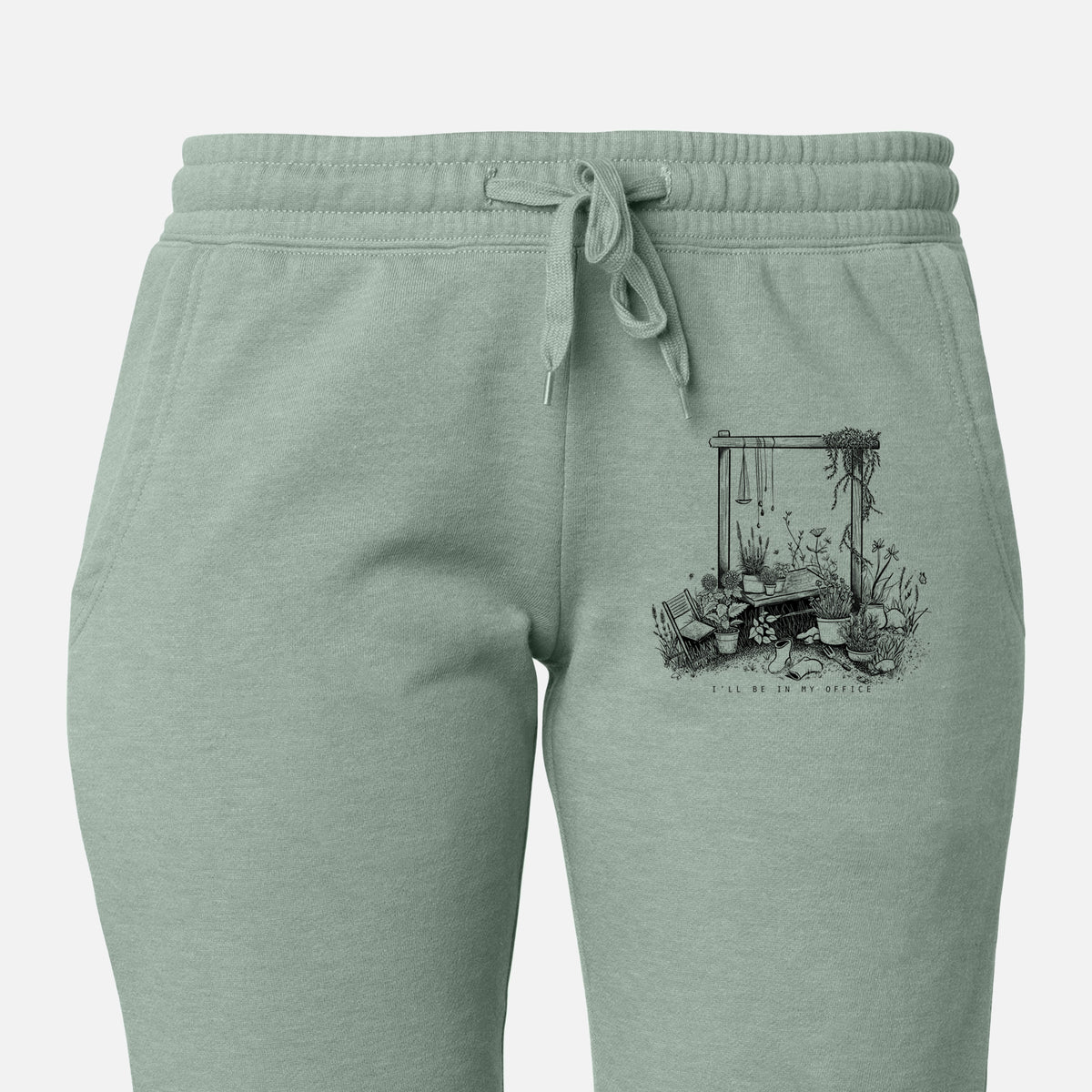 Front of sage green Cali Wave sweatpants, printed with a black ink illustration of a garden gate arch surrounded by potted plants and flowers on the leg.