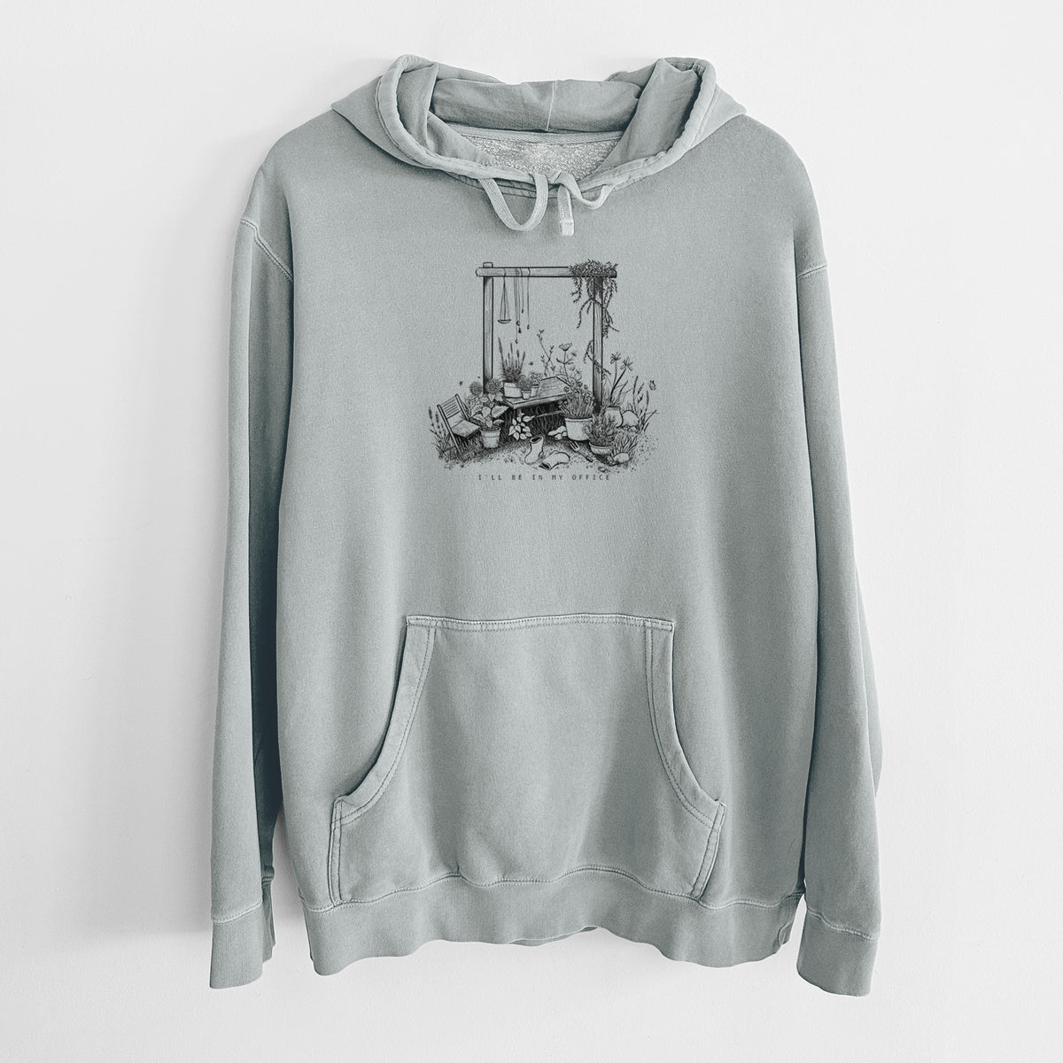 Sage green pigment dyed hoodie laid flat, printed with a black ink illustration of a garden gate arch surrounded by potted plants and flowers.