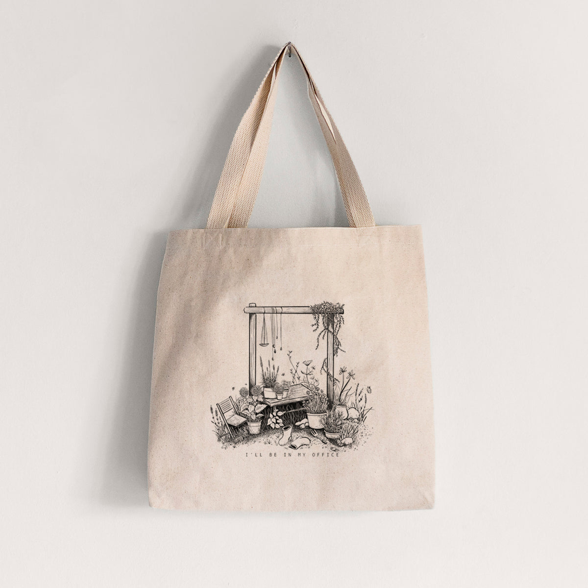 Natural canvas tote bag printed with a black ink illustration of a garden gate arch surrounded by potted plants and flowers.