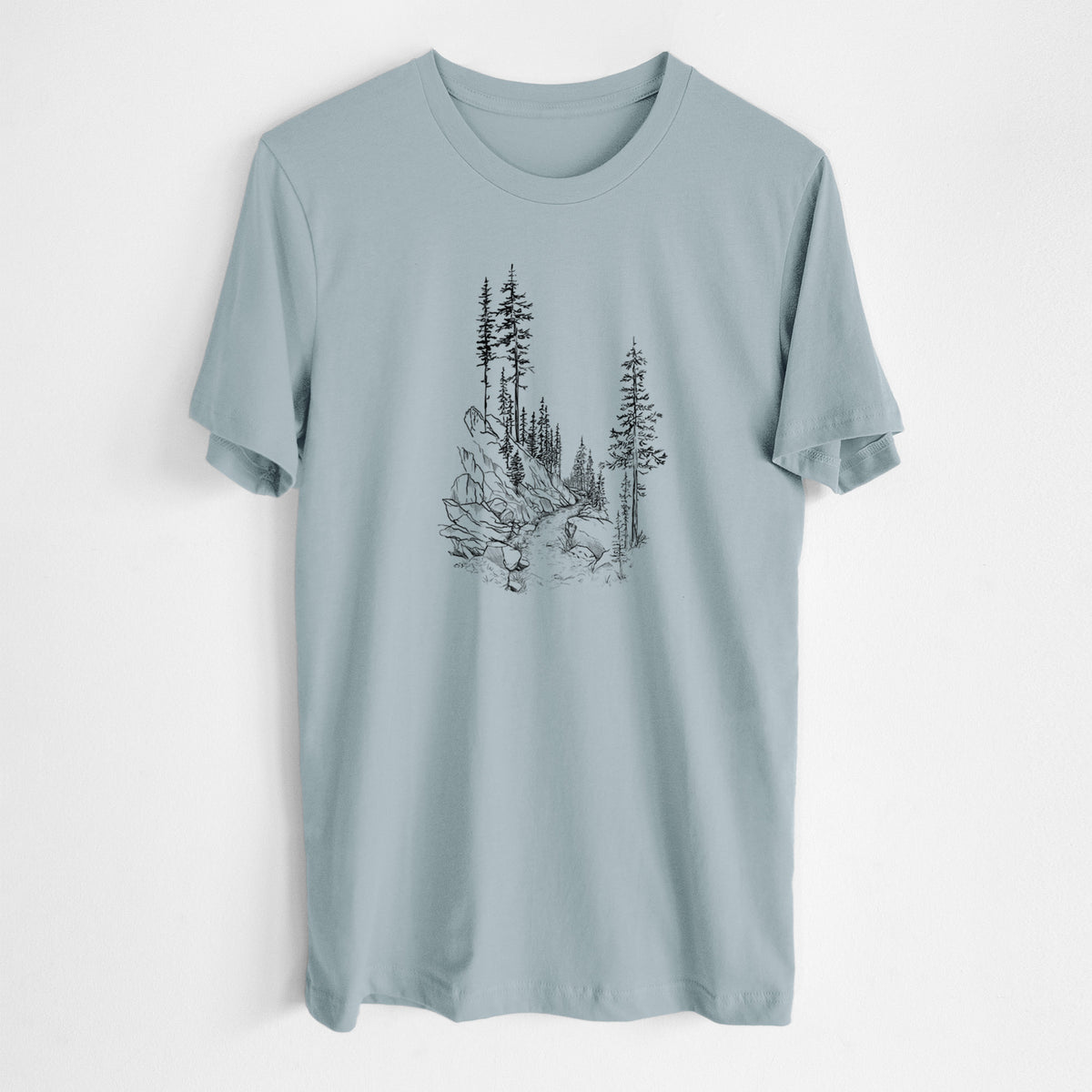 Vintage denim lightweight cotton t-shirt laid flat, printed with a black ink illustration of a trail winding past tall pine trees and rocks into the woods.
