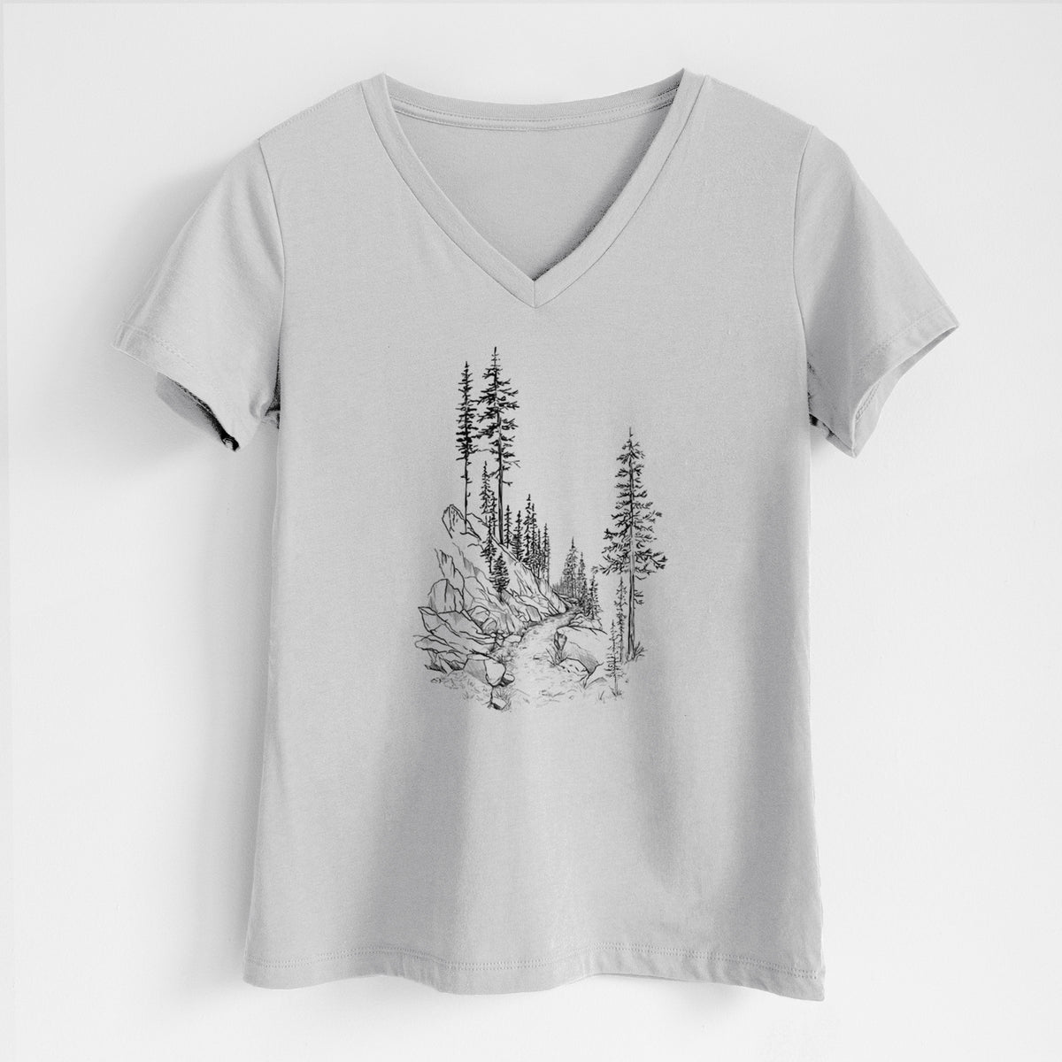 Lunar grey women's relaxed fit cotton V-neck t-shirt laid flat, printed with a black ink illustration of a trail winding past tall pine trees and rocks into the woods.