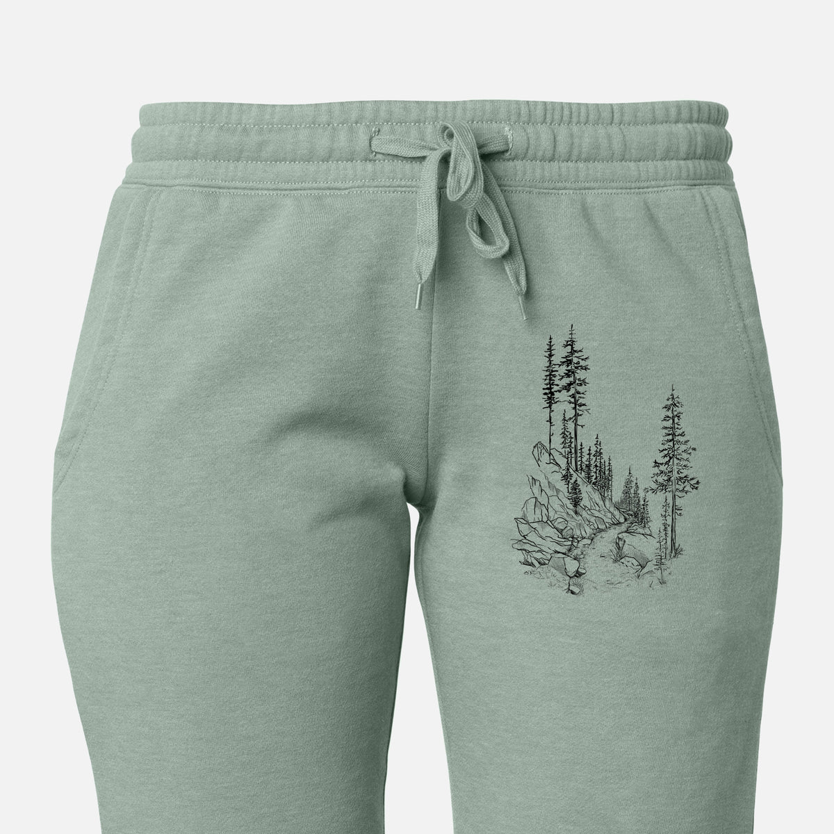 Front of sage green Cali Wave sweatpants, printed with a black ink illustration of a trail winding past tall pine trees and rocks into the woods on the leg.