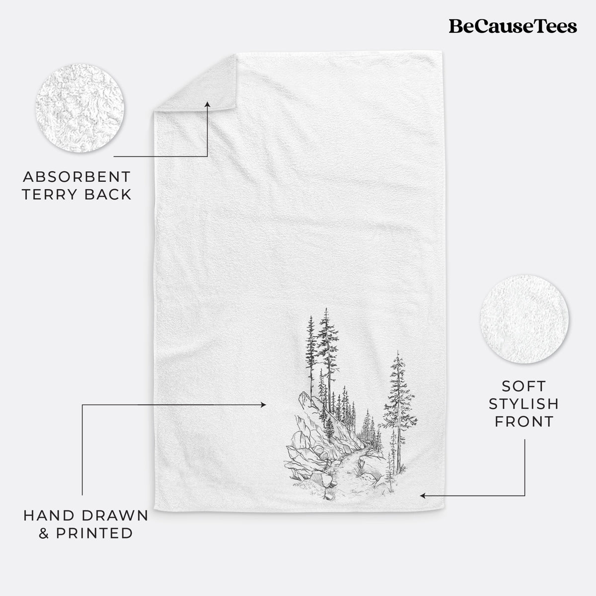 White hand towel printed with a black ink illustration of a trail winding past tall pine trees and rocks into the woods.