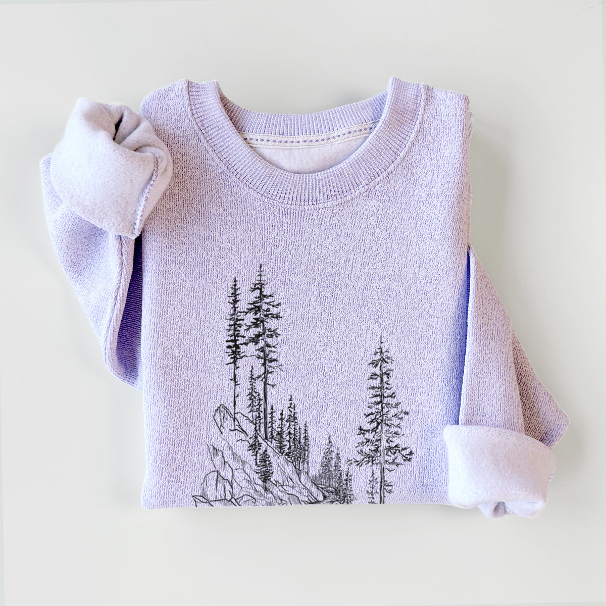 Ice purple knit sweatshirt printed with a black ink illustration of a trail winding past tall pine trees and rocks into the woods, styled flat.