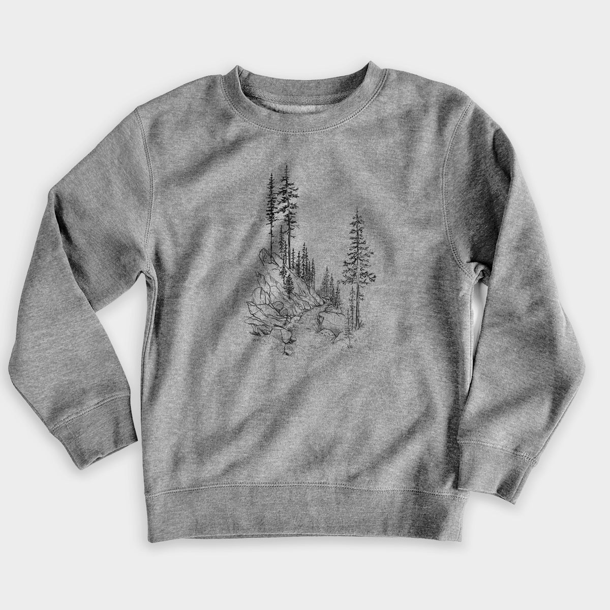 Nickel grey youth crewneck sweatshirt laid flat, printed with a black ink illustration of a trail winding past tall pine trees and rocks into the woods.