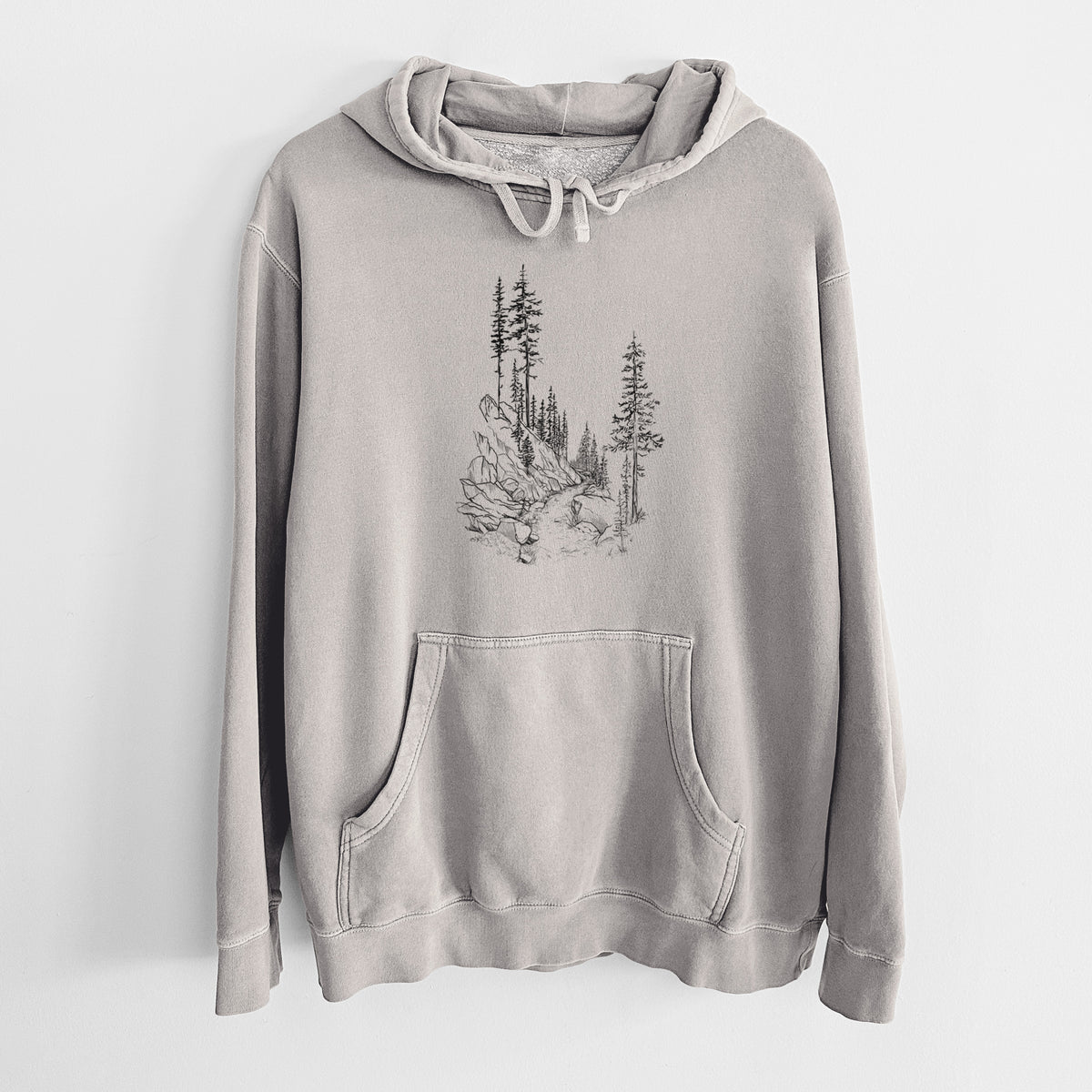 Cement grey pigment dyed hoodie laid flat, printed with a black ink illustration of a trail winding past tall pine trees and rocks into the woods.