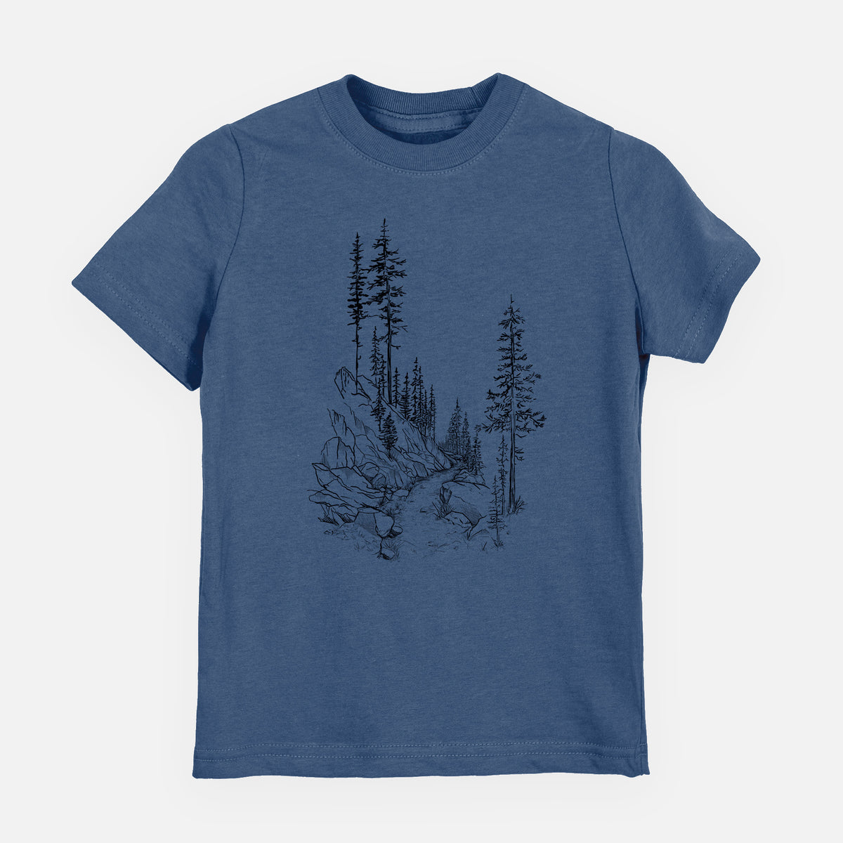 Indigo blue youth t-shirt laid flat, printed with a black ink illustration of a trail winding past tall pine trees and rocks into the woods.