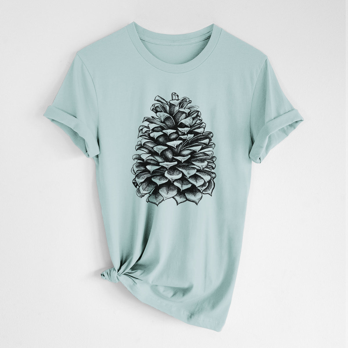 Dusty blue lightweight cotton t-shirt laid flat with the sleeves rolled, printed with a detailed black ink illustration of a large Jeffrey pine cone.