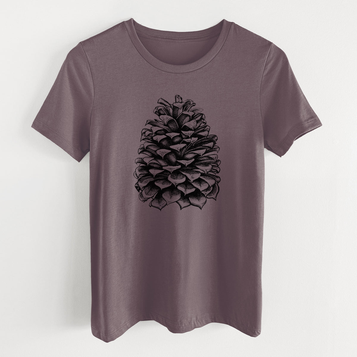 Purple storm women's relaxed fit cotton t-shirt laid flat, printed with a detailed black ink illustration of a large Jeffrey pine cone.