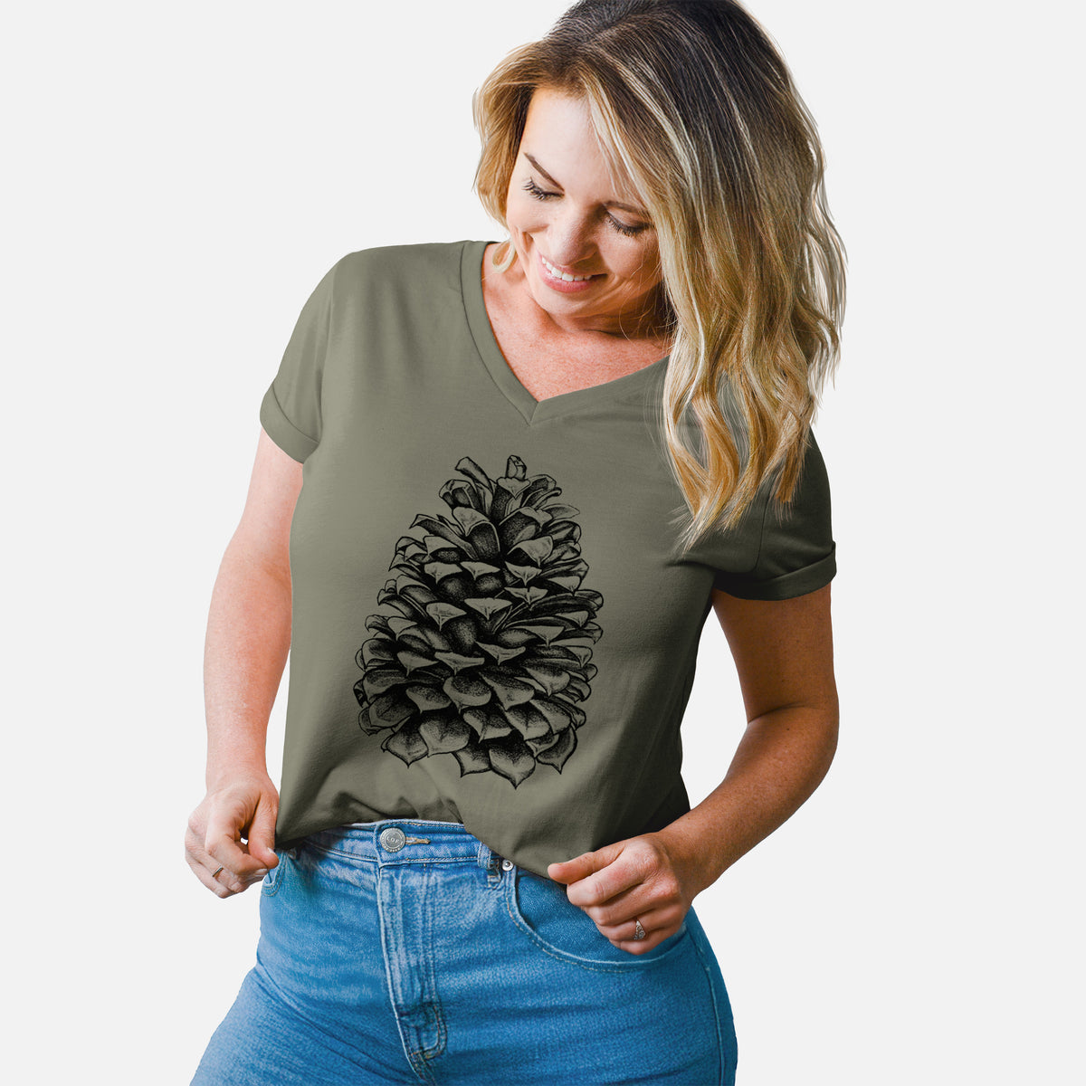 Woman wearing a military green women's relaxed fit cotton V-neck t-shirt printed with a detailed black ink illustration of a large Jeffrey pine cone.