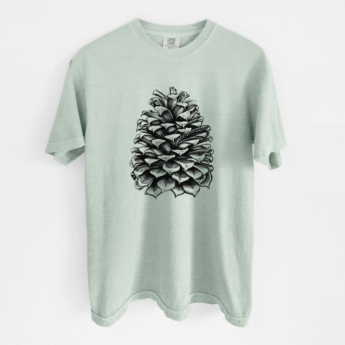 Bay green Comfort Colors t-shirt laid flat, printed with a detailed black ink illustration of a large Jeffrey pine cone.