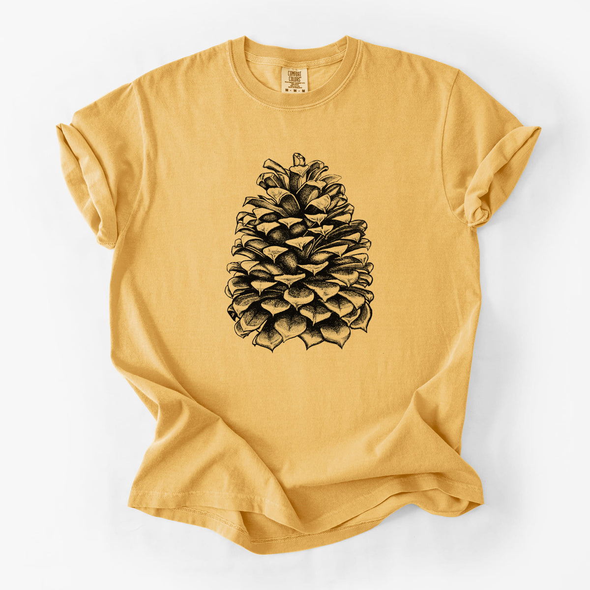 Golden wheat yellow Comfort Colors t-shirt laid flat, printed with a detailed black ink illustration of a large Jeffrey pine cone.