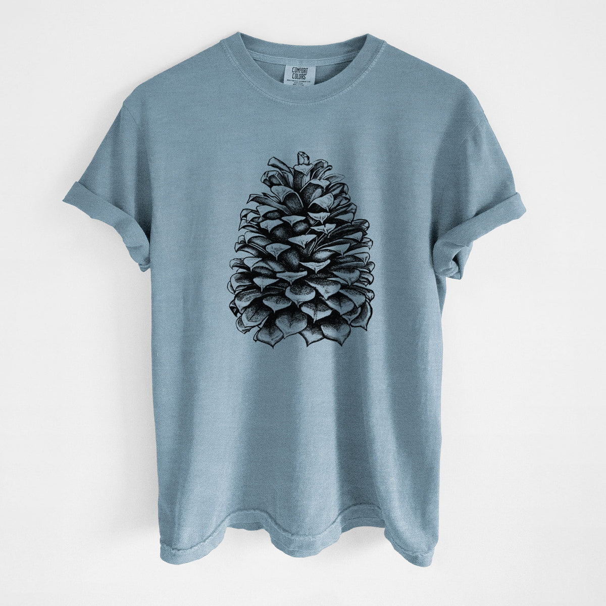 Steel blue Comfort Colors t-shirt laid flat, printed with a detailed black ink illustration of a large Jeffrey pine cone.