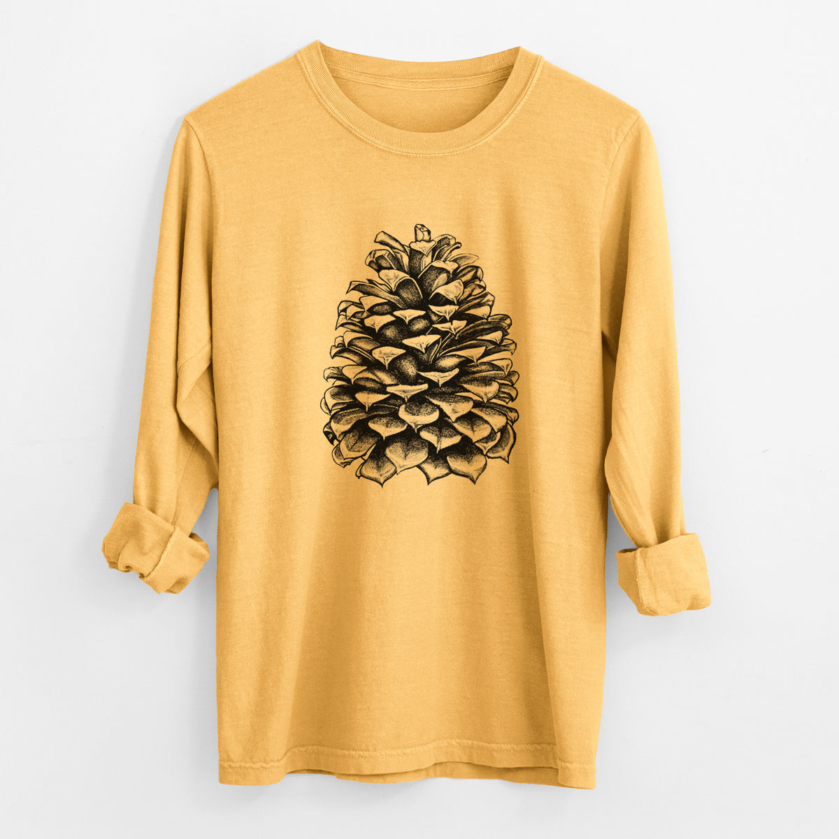 Golden wheat yellow Comfort Colors long sleeve shirt laid flat with the cuffs rolled, printed with a detailed black ink illustration of a large Jeffrey pine cone.