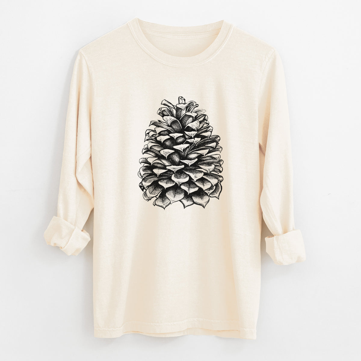 Ivory Comfort Colors long sleeve shirt laid flat with the cuffs rolled, printed with a detailed black ink illustration of a large Jeffrey pine cone.