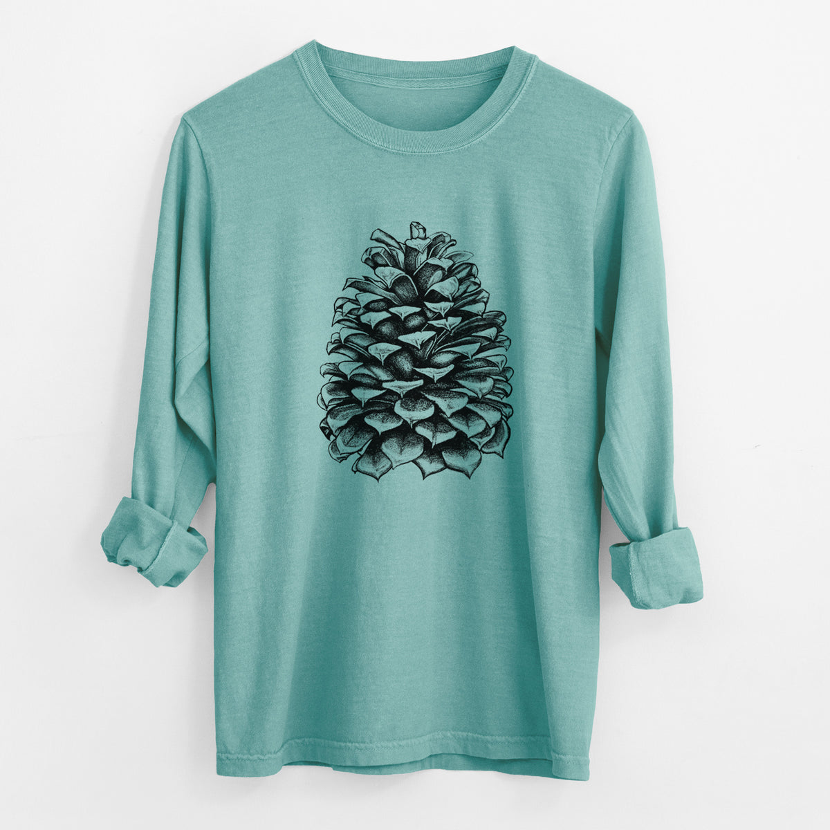 Reef green Comfort Colors long sleeve shirt laid flat with the cuffs rolled, printed with a detailed black ink illustration of a large Jeffrey pine cone.