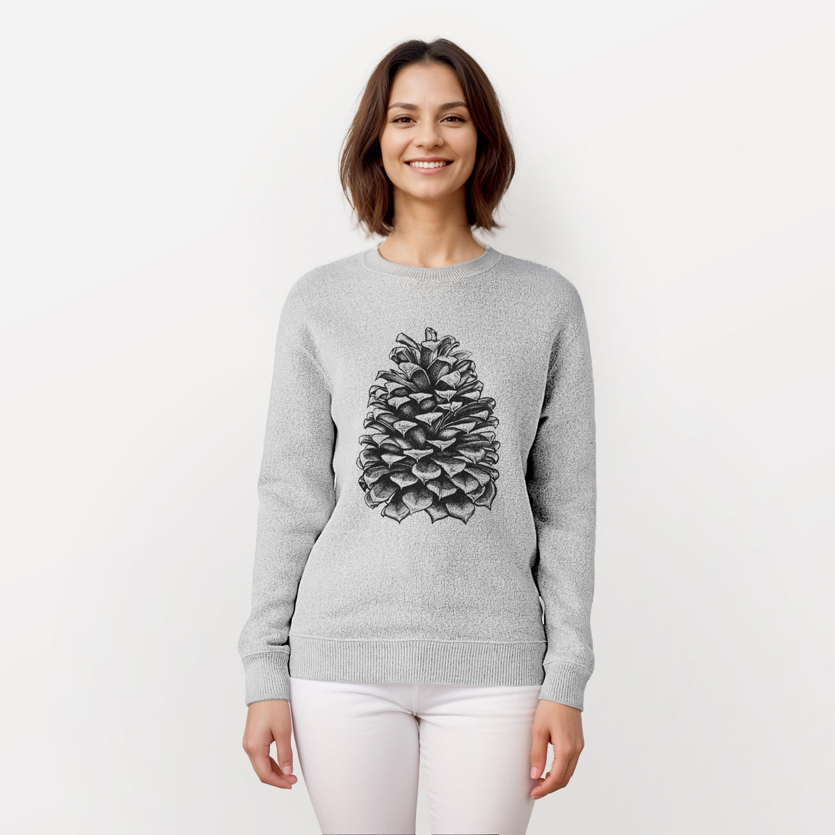 Woman wearing a knit sweatshirt printed with a detailed black ink illustration of a large Jeffrey pine cone.