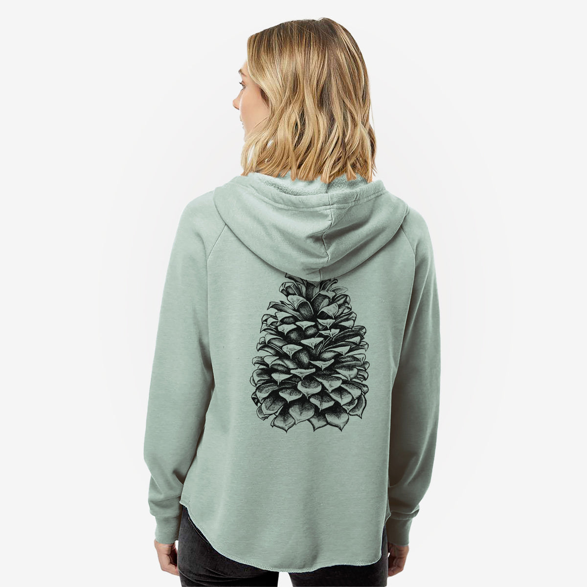 Woman wearing a sage green women's Cali Wave zip-up sweatshirt printed with a detailed black ink illustration of a large Jeffrey pine cone, seen from behind.