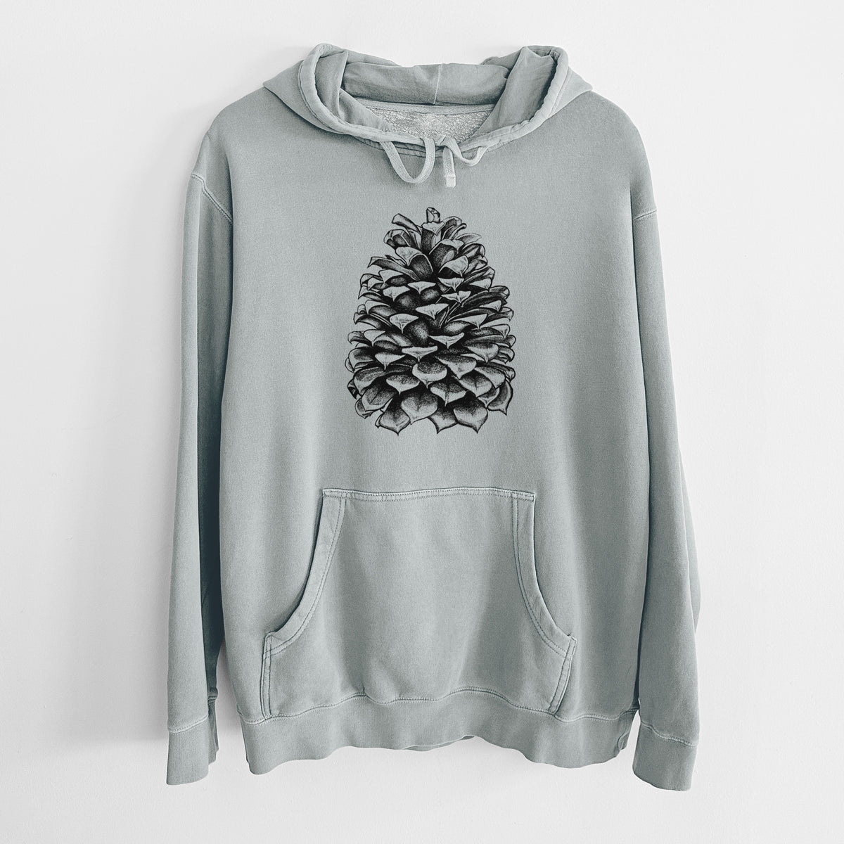 Sage green pigment dyed hoodie laid flat, printed with a detailed black ink illustration of a large Jeffrey pine cone.